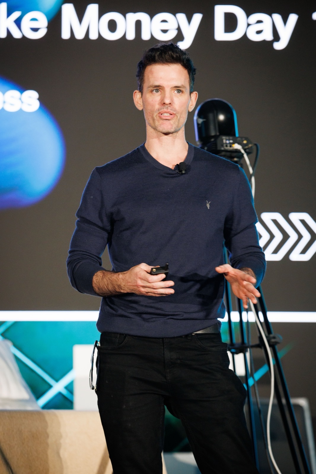 Chris Santos speaking on stage at a conference